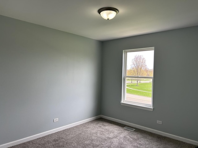 carpeted empty room featuring baseboards and visible vents