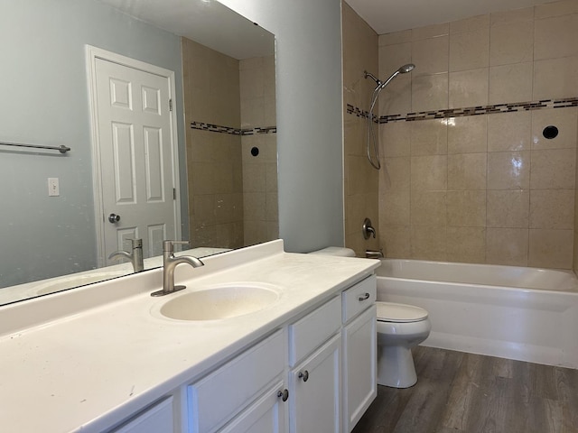 bathroom with toilet,  shower combination, wood finished floors, and vanity