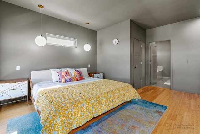 bedroom with wood finished floors and ensuite bath