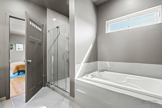 full bathroom with a shower stall and a bath