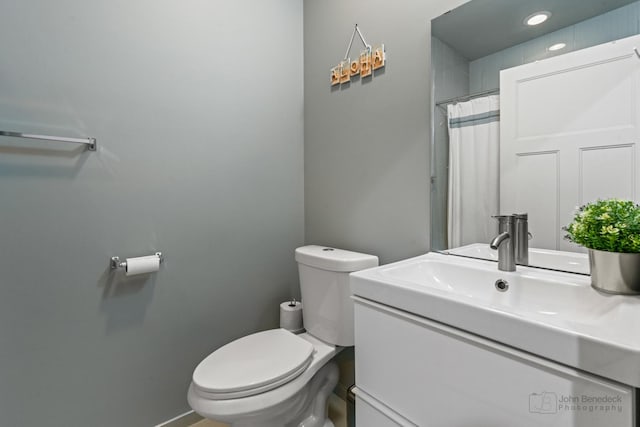 bathroom featuring toilet, vanity, and baseboards