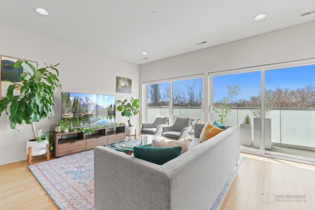living room featuring wood finished floors, visible vents, and recessed lighting