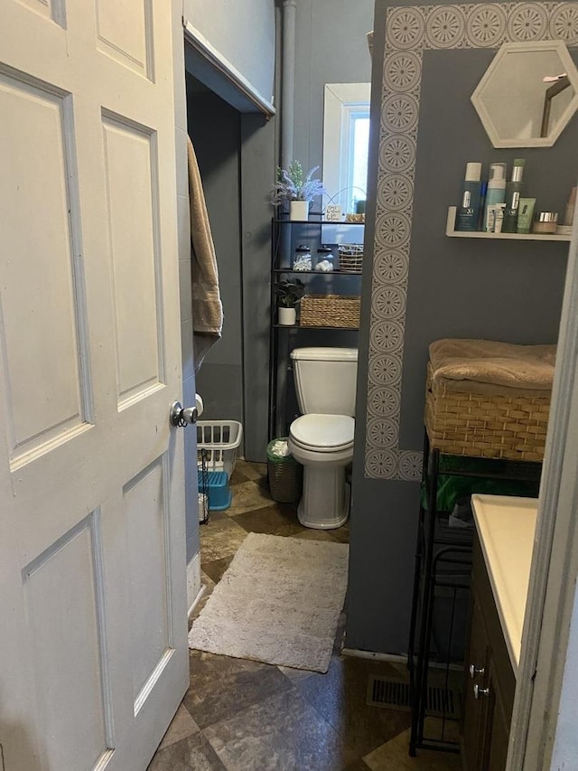 bathroom featuring stone finish flooring and toilet