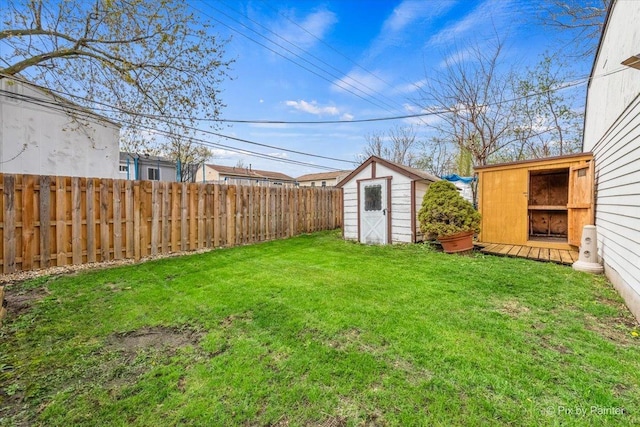 view of yard with a storage unit, fence, and an outbuilding