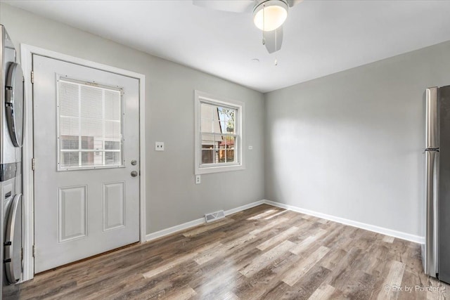 interior space with a ceiling fan, baseboards, visible vents, and wood finished floors