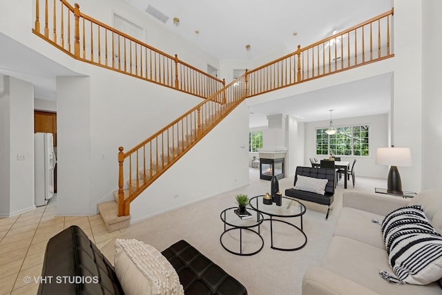 2505 Camberley Cir Unit 3-813, Westchester, IL 60154 - living area with a high ceiling, stairs, baseboards, and a tiled fireplace