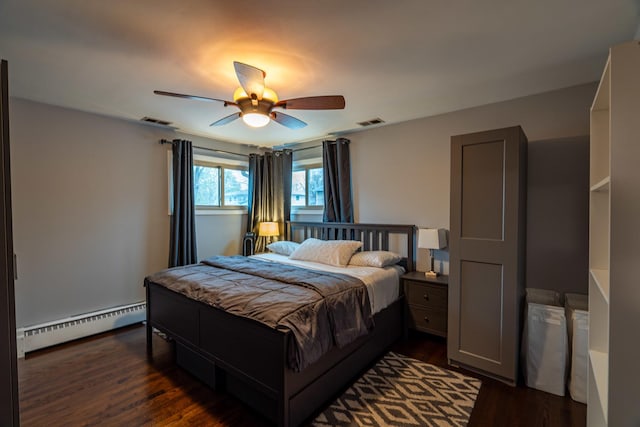 bedroom with a baseboard heating unit, a ceiling fan, dark wood-style flooring, and visible vents