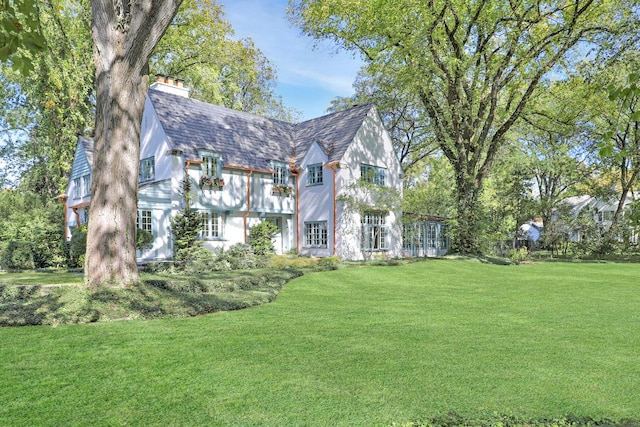 180 De Windt Rd, Winnetka, IL 60093 - tudor-style house featuring a front yard and a chimney