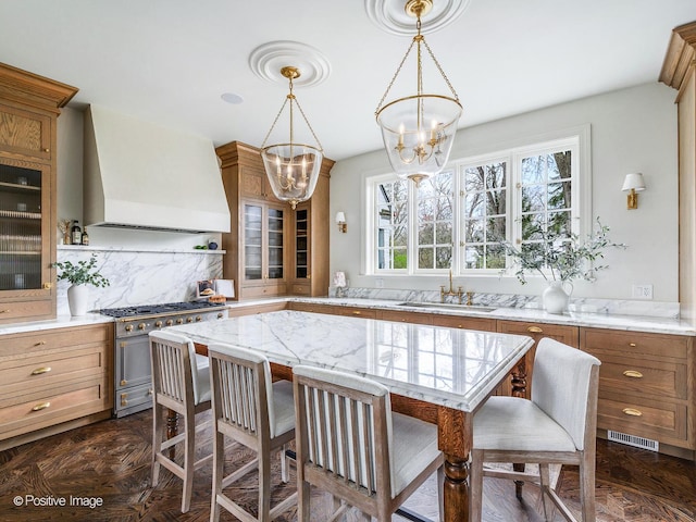 180 De Windt Rd, Winnetka, IL 60093 - kitchen with an inviting chandelier, glass insert cabinets, premium range hood, a sink, and high end range