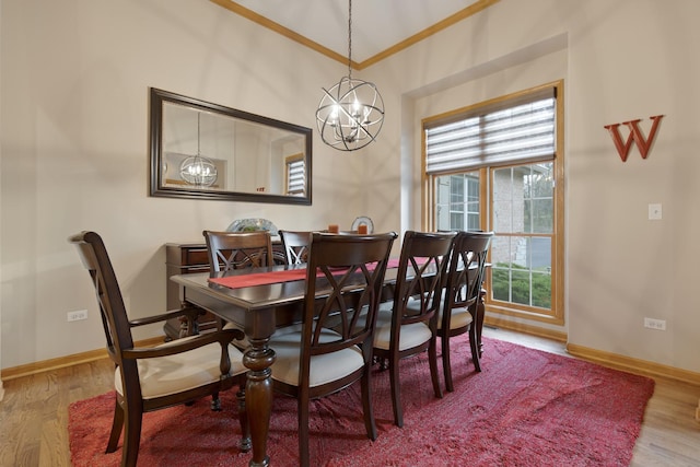 dining space featuring a chandelier, baseboards, wood finished floors, and ornamental molding
