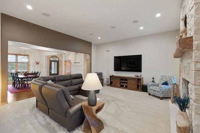 carpeted living room with a fireplace, visible vents, and recessed lighting