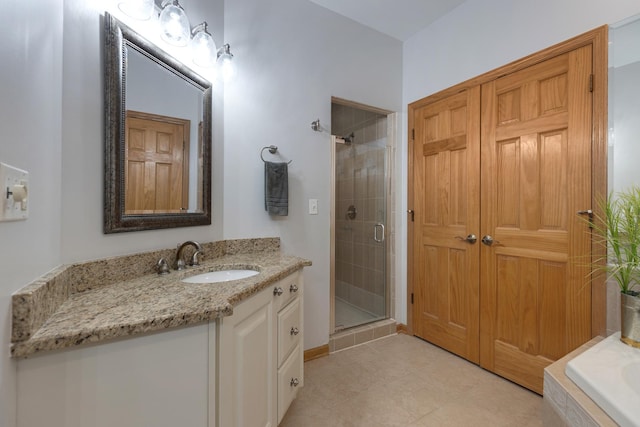 full bath with a shower stall, tile patterned flooring, a washtub, and vanity
