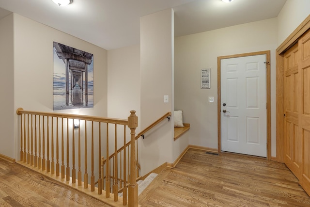 foyer with baseboards and light wood-style floors