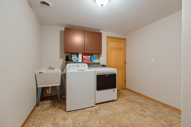 washroom with baseboards, cabinet space, washing machine and clothes dryer, and visible vents