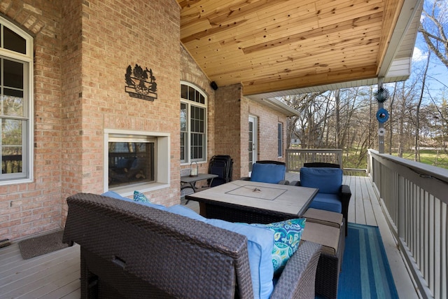 wooden terrace featuring an outdoor living space with a fireplace