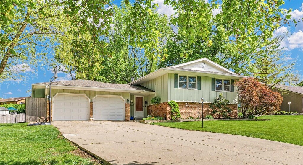 1 Genevieve Ct, Champaign, IL 61822 - tri-level home featuring a front yard, brick siding, board and batten siding, concrete driveway, and an attached garage