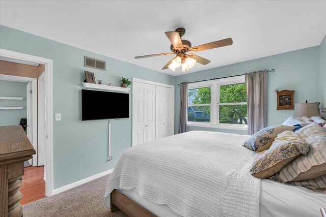bedroom with a closet, visible vents, baseboards, ceiling fan, and carpet flooring