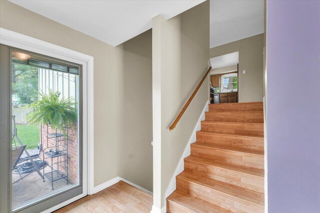 stairway with baseboards and wood finished floors