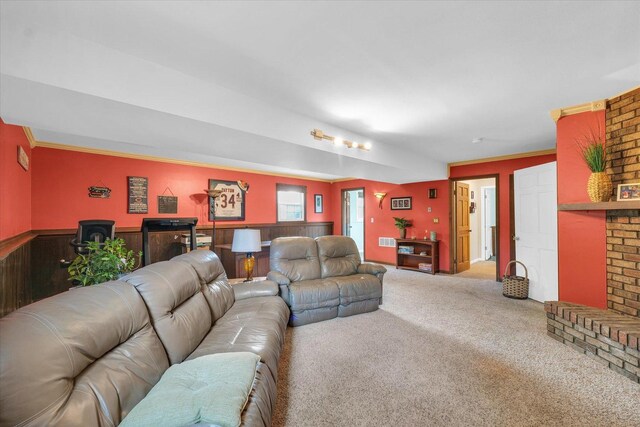 living area featuring visible vents, ornamental molding, carpet, and a wainscoted wall