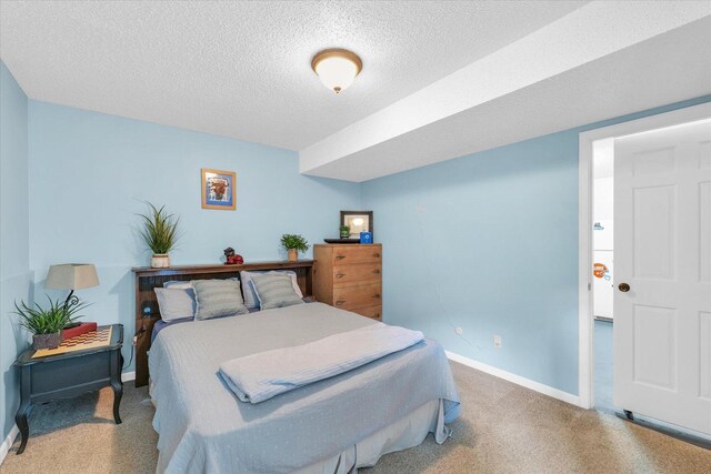 carpeted bedroom featuring a textured ceiling and baseboards