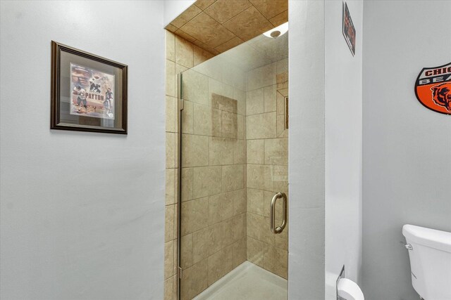 bathroom with toilet and a stall shower