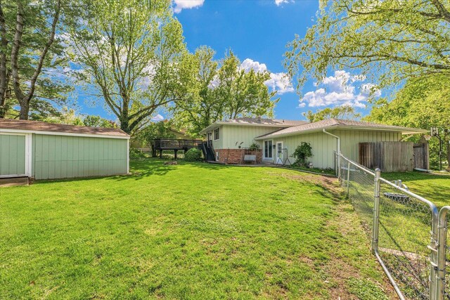 view of yard featuring fence, an outdoor structure, and a storage unit