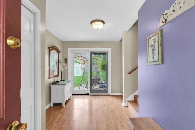 doorway to outside featuring stairway, baseboards, and light wood-style flooring