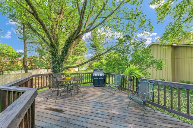 deck with fence, area for grilling, and outdoor dining space
