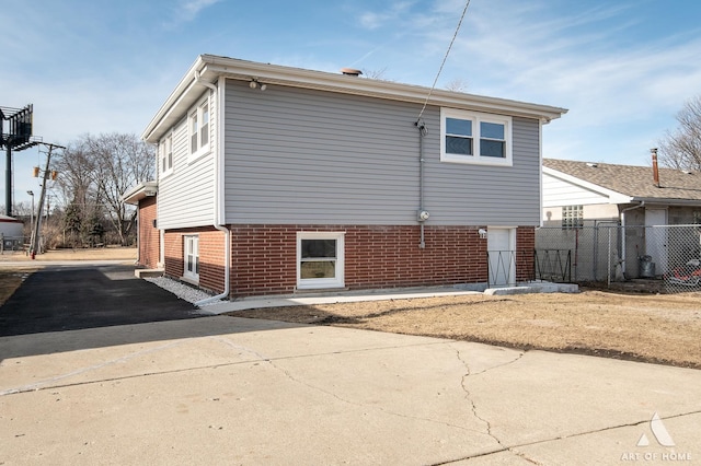 10945 S Neenah Ave, Worth, IL 60482 - view of home's exterior featuring fence, aphalt driveway, and brick siding
