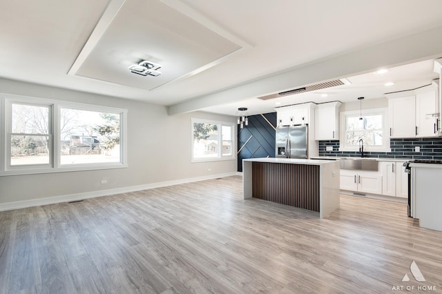 10945 S Neenah Ave, Worth, IL 60482 - kitchen with a center island, open floor plan, light wood-type flooring, stainless steel fridge, and decorative light fixtures