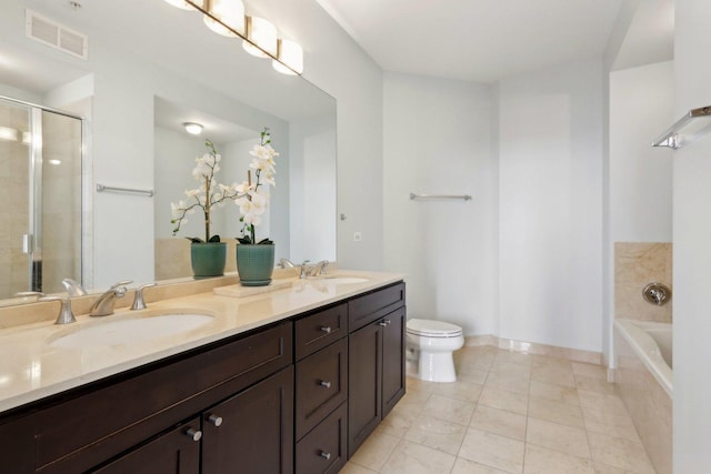 bathroom with a shower stall, toilet, a sink, and visible vents