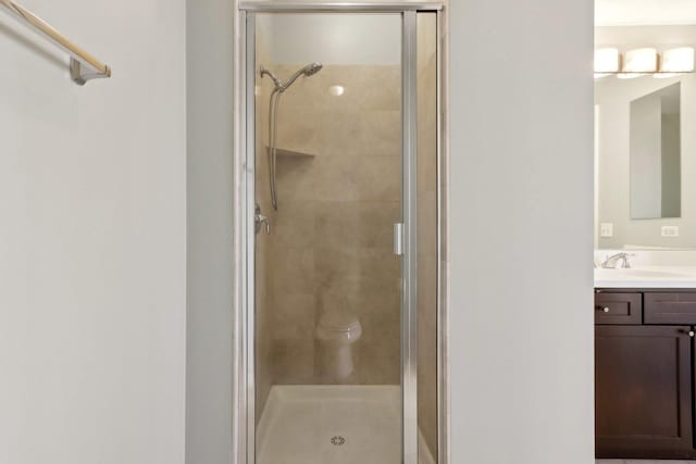 bathroom featuring a shower stall and vanity