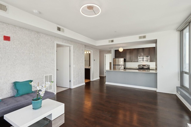 unfurnished living room with visible vents and dark wood-type flooring