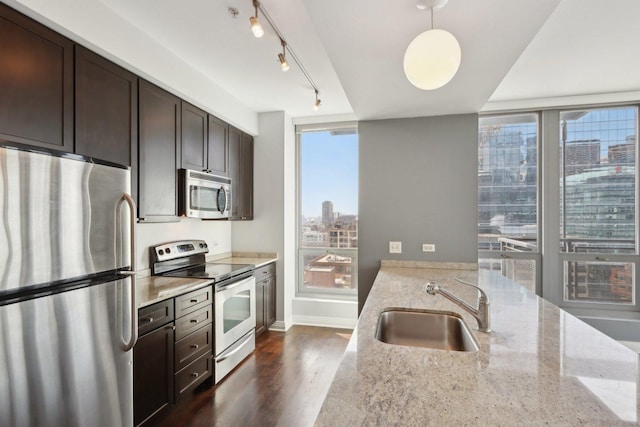 kitchen with a wealth of natural light, a view of city, stainless steel appliances, and a sink