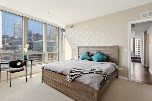 bedroom featuring visible vents, carpet, and multiple windows