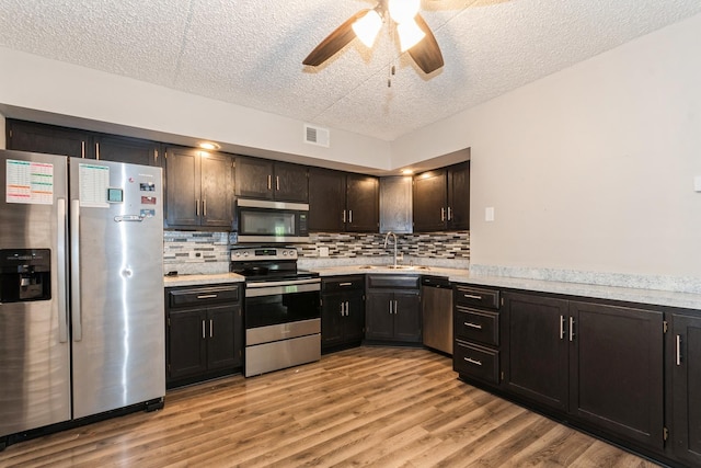 1472 N Rock Run Dr Unit 1C, Crest Hill, IL 60403 - kitchen featuring appliances with stainless steel finishes, a textured ceiling, a sink, light countertops, and a ceiling fan