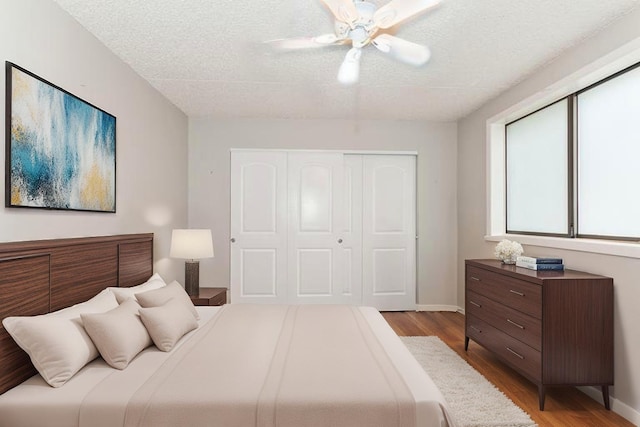 1472 N Rock Run Dr Unit 1C, Crest Hill, IL 60403 - bedroom with a closet, wood finished floors, a textured ceiling, baseboards, and a ceiling fan