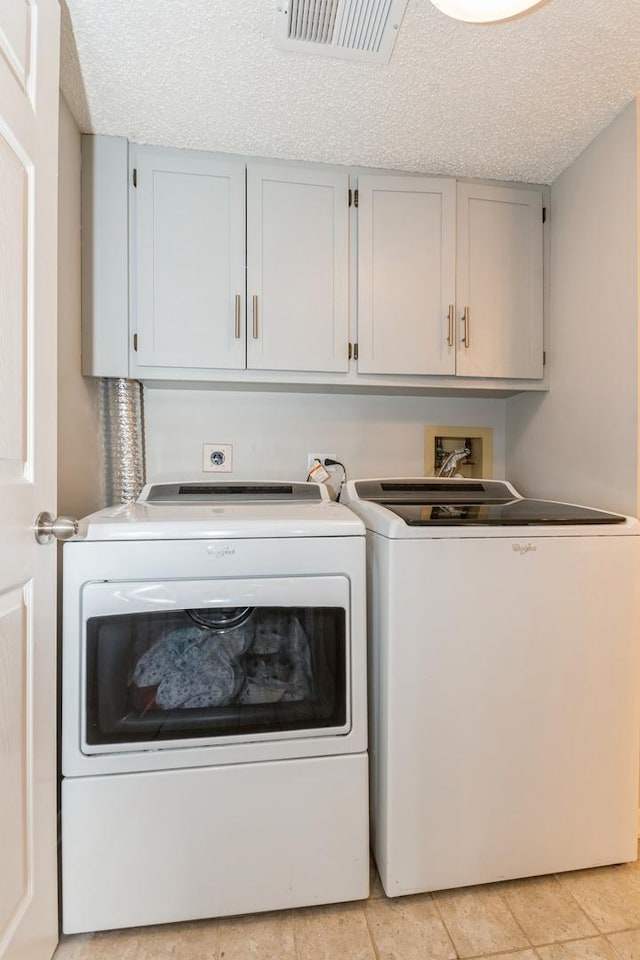 1472 N Rock Run Dr Unit 1C, Crest Hill, IL 60403 - laundry area with cabinet space, washing machine and clothes dryer, a textured ceiling, and light tile patterned floors