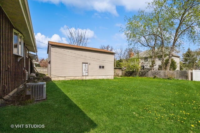 view of yard with central AC and fence