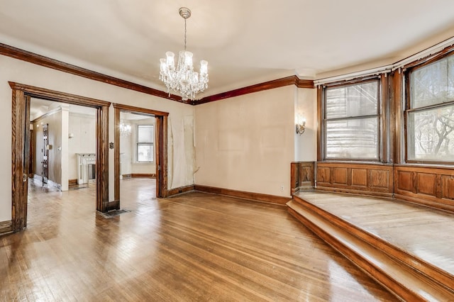 1312 N Astor St, Chicago, IL 60610 - empty room with light wood finished floors, a chandelier, crown molding, and baseboards