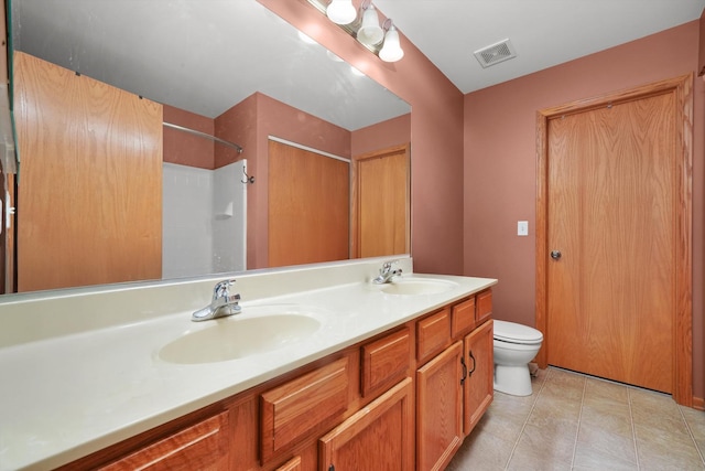 bathroom with double vanity, toilet, visible vents, and a sink