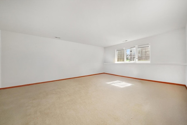 carpeted empty room featuring baseboards