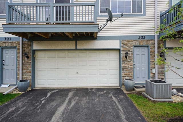 garage featuring central air condition unit and driveway
