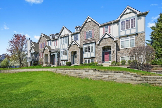view of front facade with a residential view, a front lawn, and stone siding