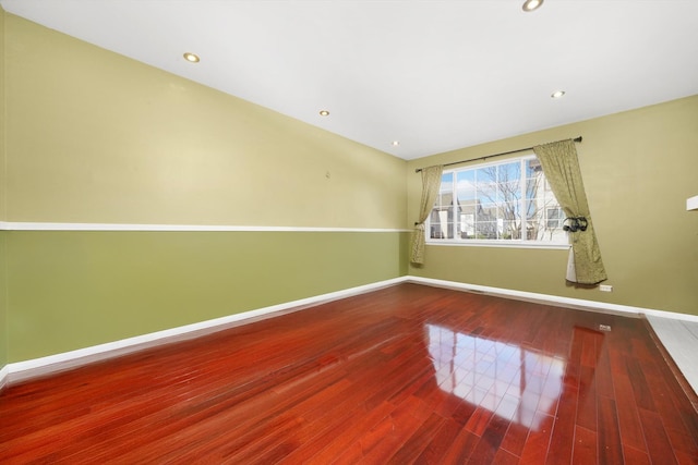 empty room with baseboards, recessed lighting, and wood finished floors