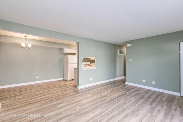 7923 163rd Ct Unit 23, Tinley Park, IL 60477 - empty room with light wood-style flooring, a chandelier, and baseboards