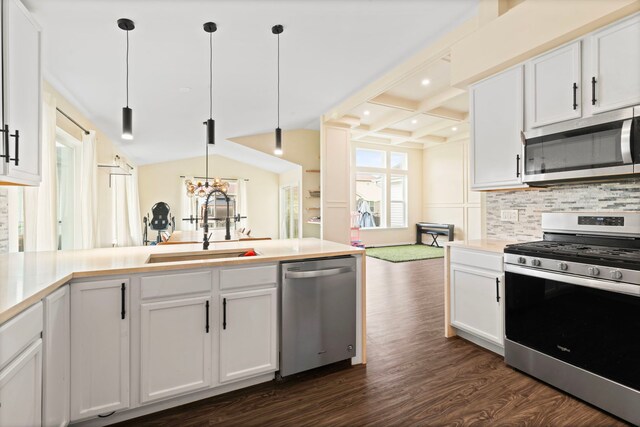 kitchen featuring white cabinets, appliances with stainless steel finishes, a sink, decorative backsplash, and dark wood-style floors