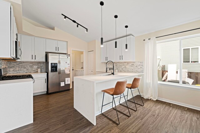 kitchen with a sink, stainless steel appliances, a peninsula, lofted ceiling, and washer and clothes dryer