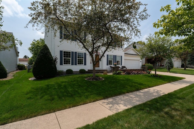 colonial house featuring an attached garage, a front yard, and concrete driveway