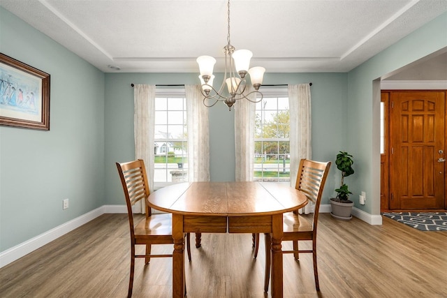 dining area featuring a notable chandelier, a healthy amount of sunlight, and light wood-style floors
